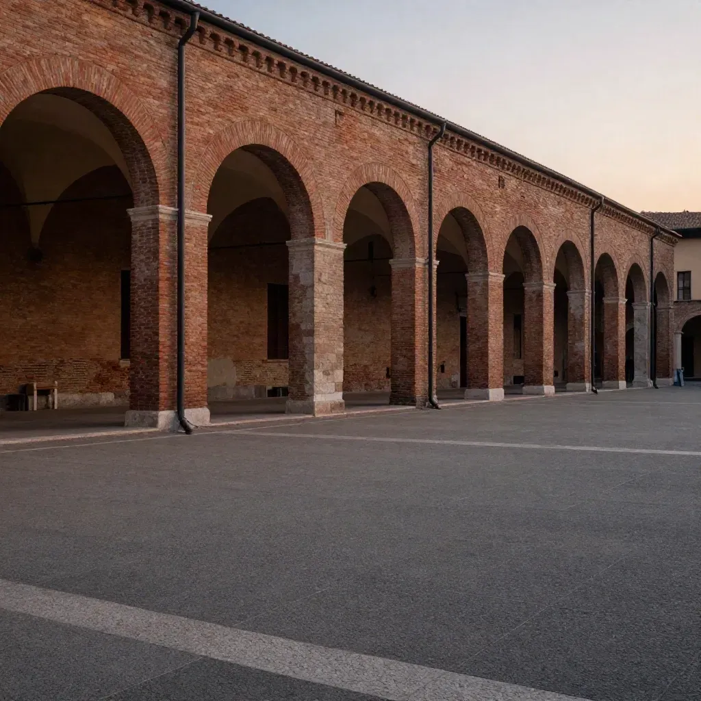 Piazza in mattoni dell’Emilia-Romagna con portici alti e cielo caldo al tramonto